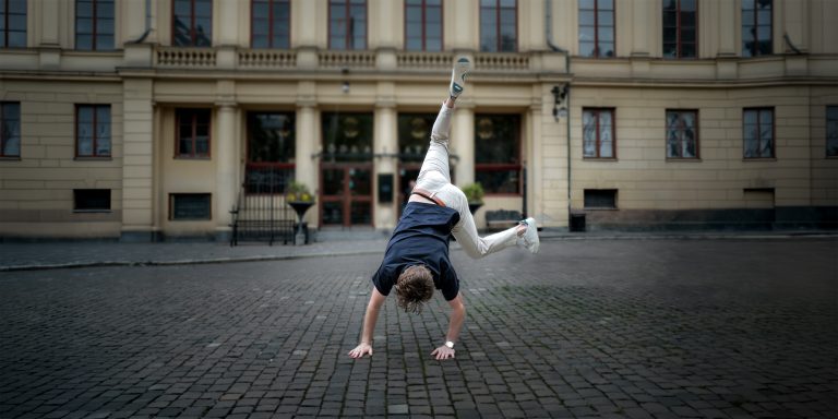 Person doing a cartwheel in a city street, representing entrepreneurship education for impact